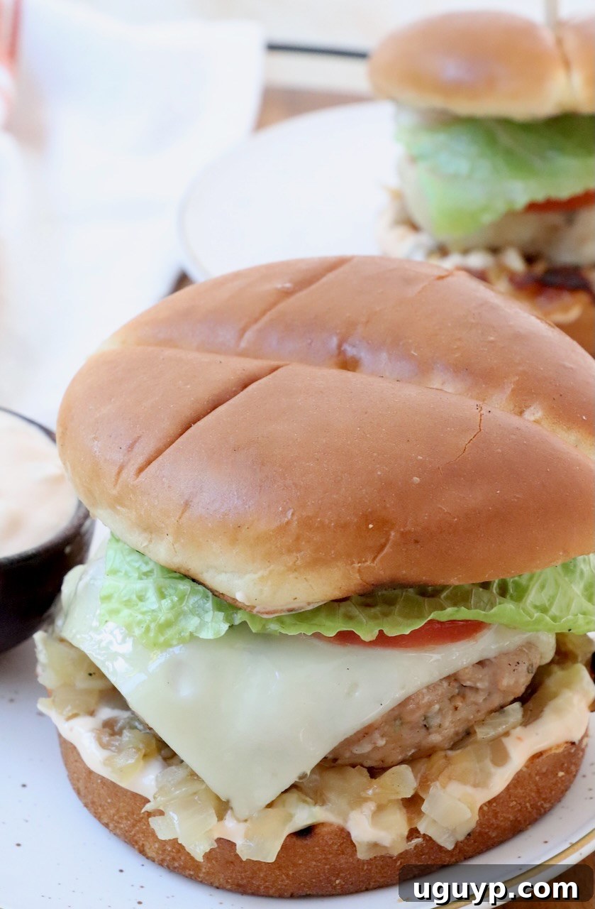 Cooked turkey burger with melted Swiss cheese, served on a toasted bun