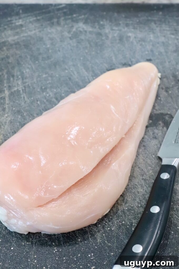 chicken breast sliced in the middle on cutting board