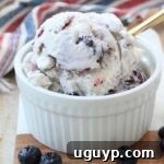 scoops of delicious homemade blueberry ice cream in a small bowl with a gold spoon, ready to be enjoyed