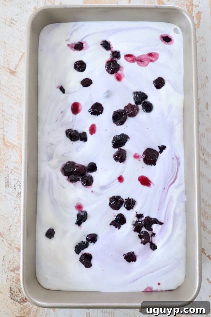 The prepared blueberry ice cream mixture poured into a metal container, ready for freezing.