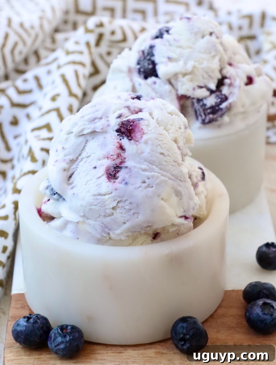 Small bowls filled with perfectly scooped homemade blueberry ice cream, ready to be enjoyed.