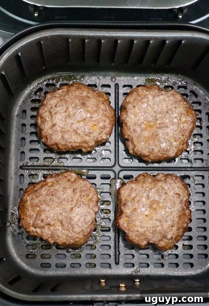 Flipped and further cooked burger patties in the air fryer.