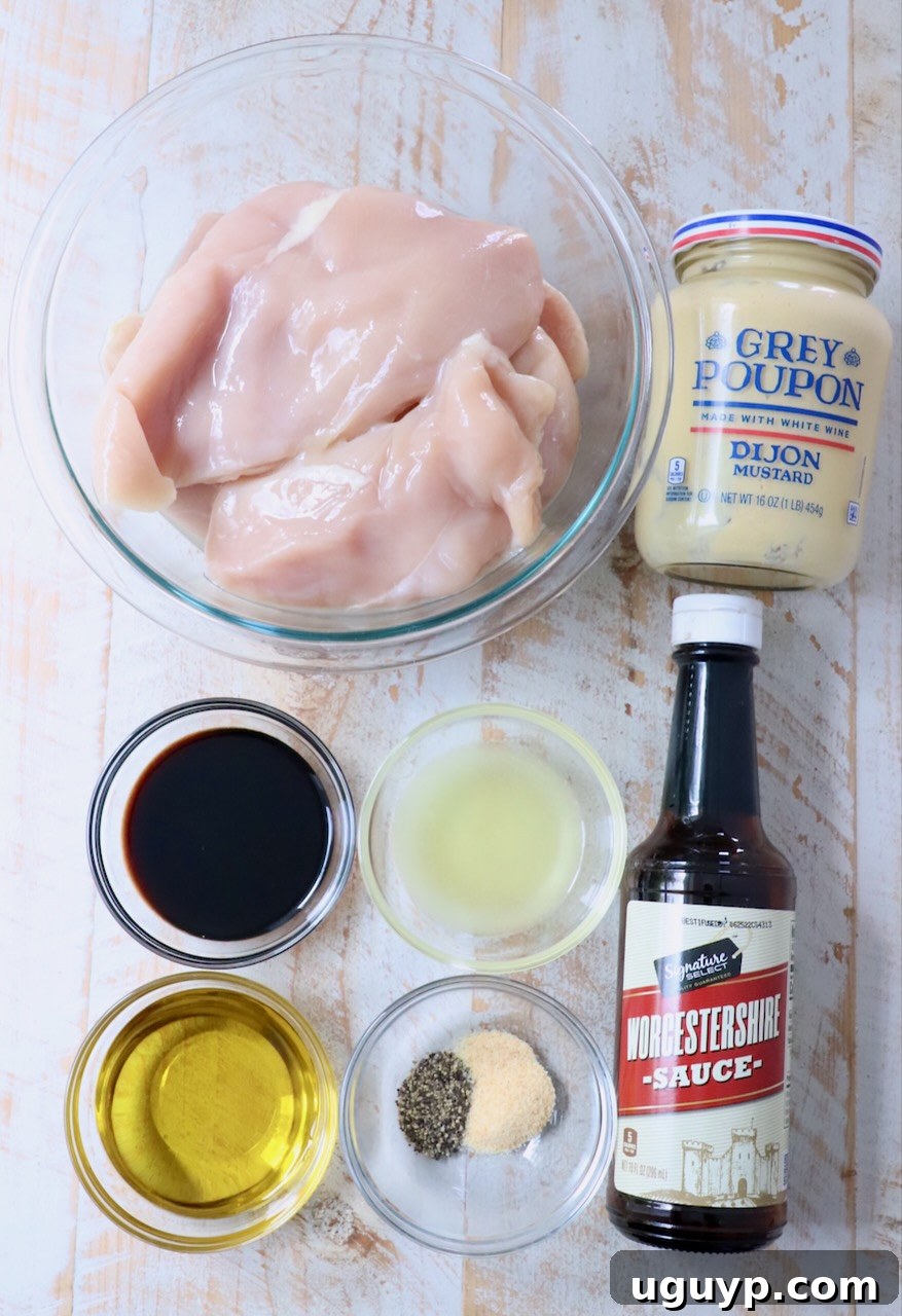 A selection of fresh ingredients for chicken marinade laid out on a white wooden board, including lemons, olive oil, soy sauce, and Dijon mustard.