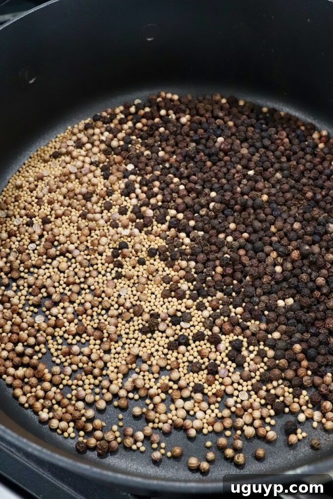 peppercorns, coriander seeds and mustard seeds toasting in a dry skillet