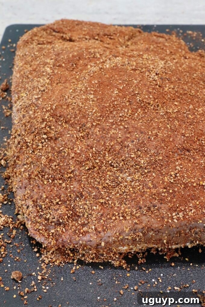 brisket generously coated with pastrami seasoning on a cutting board
