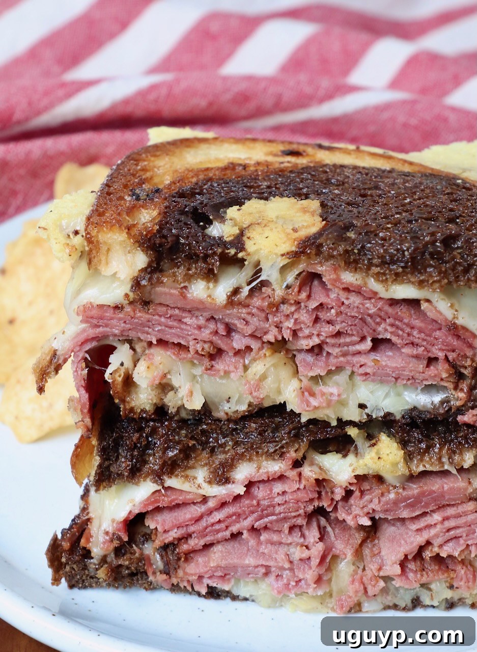 Hot Pastrami Reuben sandwich sliced in half and served on a plate, ready to eat.