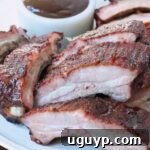 smoked pork ribs sliced on plate with bbq sauce