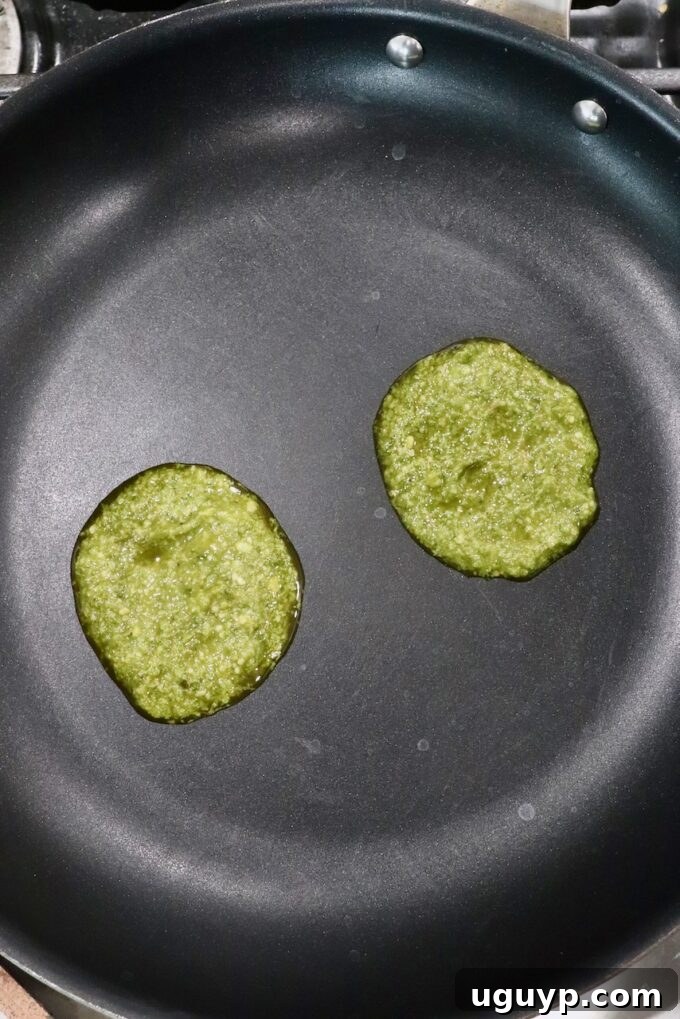 two scoops of basil pesto in skillet