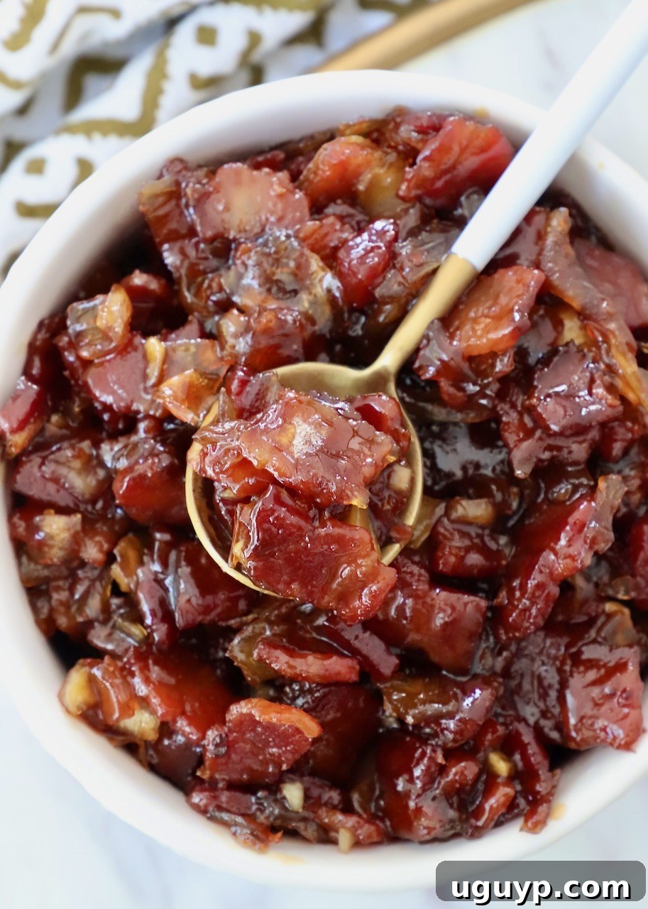 A bowl of delicious homemade bacon jam with a spoon, ready to serve.