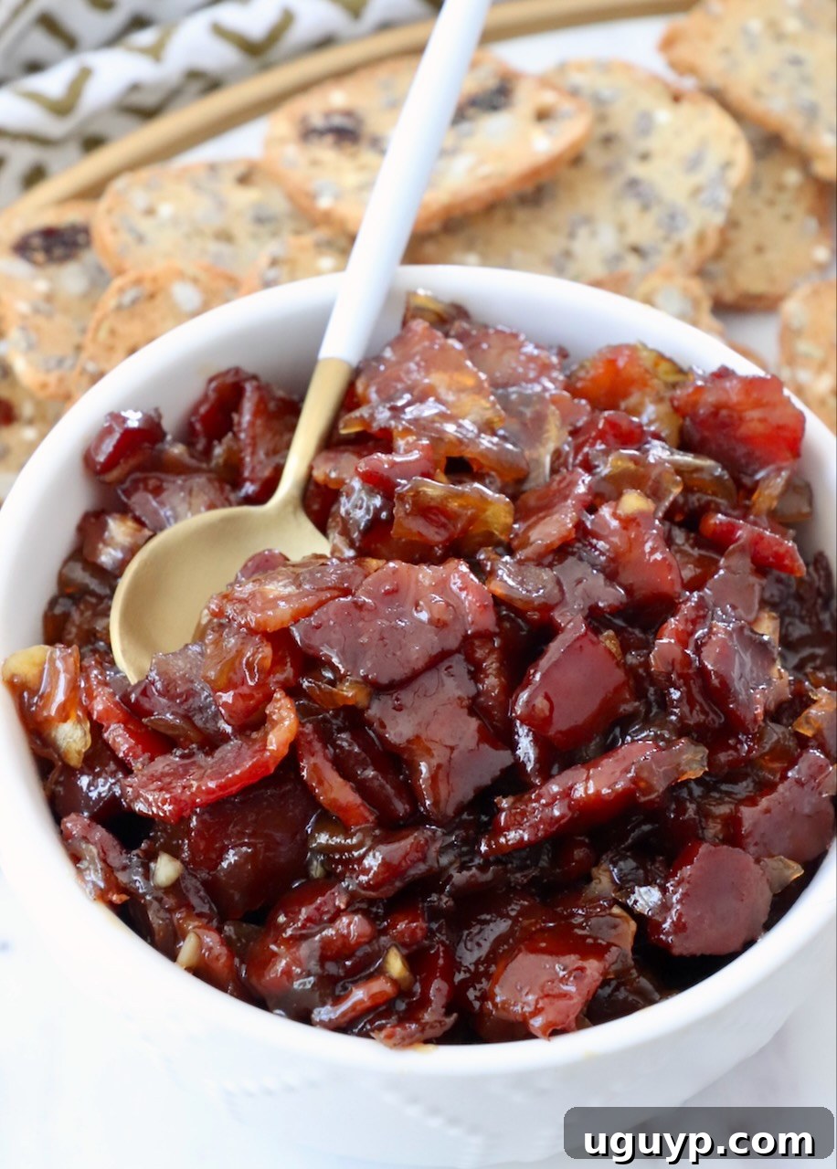 A large bowl of homemade bacon jam with a serving spoon, inviting and ready to be enjoyed.