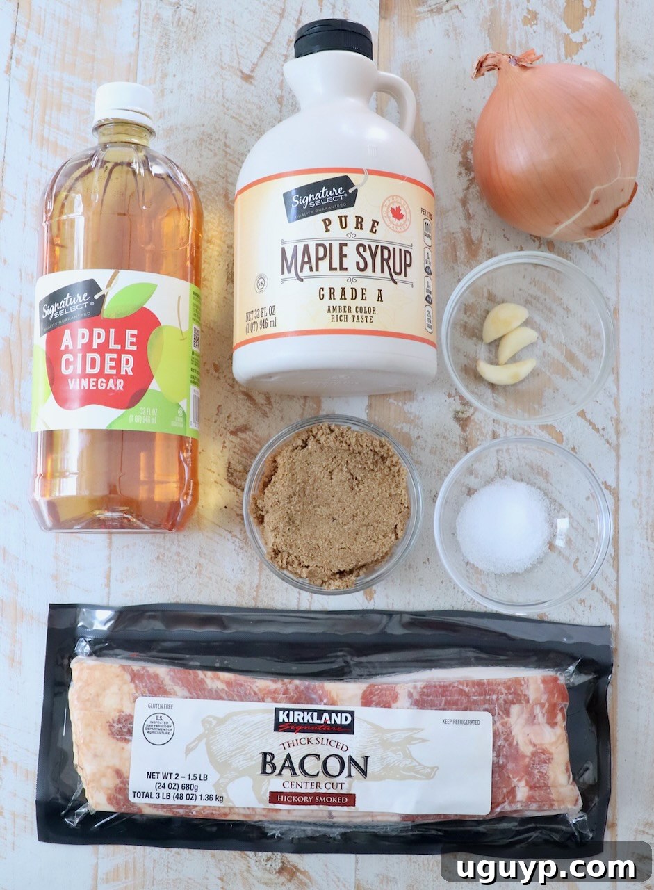 Ingredients for homemade bacon jam laid out on a white wooden board, including bacon, onions, garlic, brown sugar, maple syrup, apple cider vinegar, and salt.