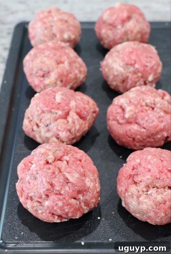 Balls of seasoned ground beef and sausage mixture ready to be smashed into patties.