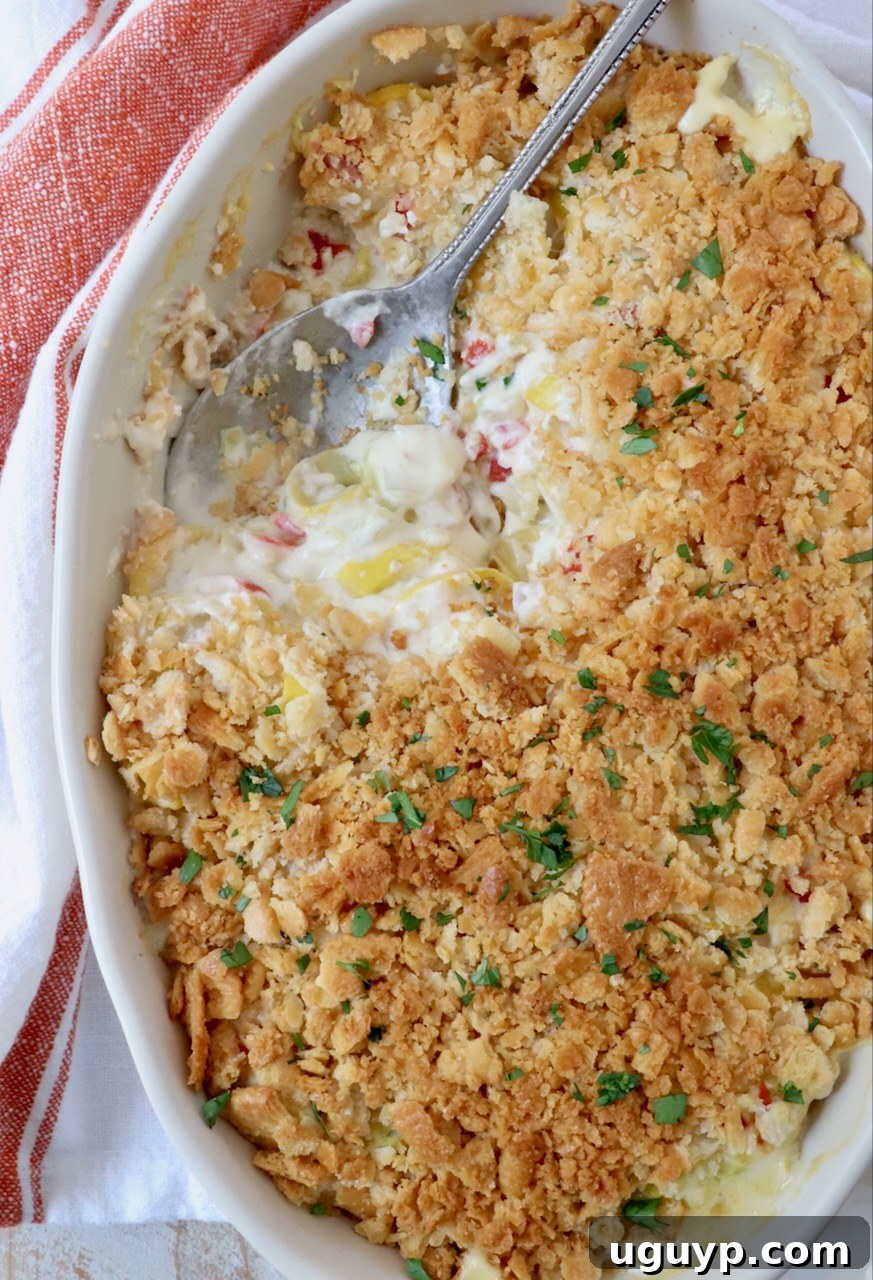 Golden-brown squash casserole with a crunchy Ritz cracker topping, served in a baking dish with a spoon.