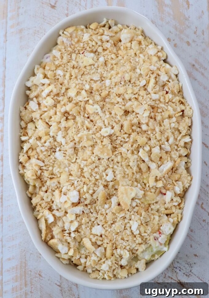 Squash casserole topped generously with the buttery cracker mixture in the baking dish, pre-baking.