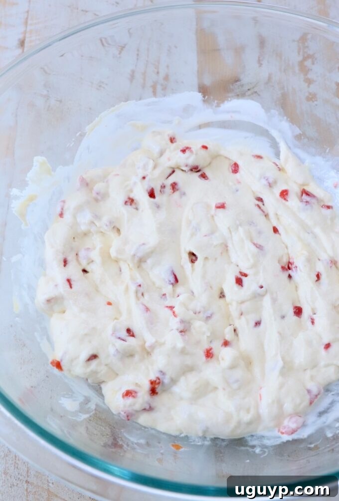 Cream of chicken soup, sour cream, and pimentos thoroughly combined in a large glass bowl.