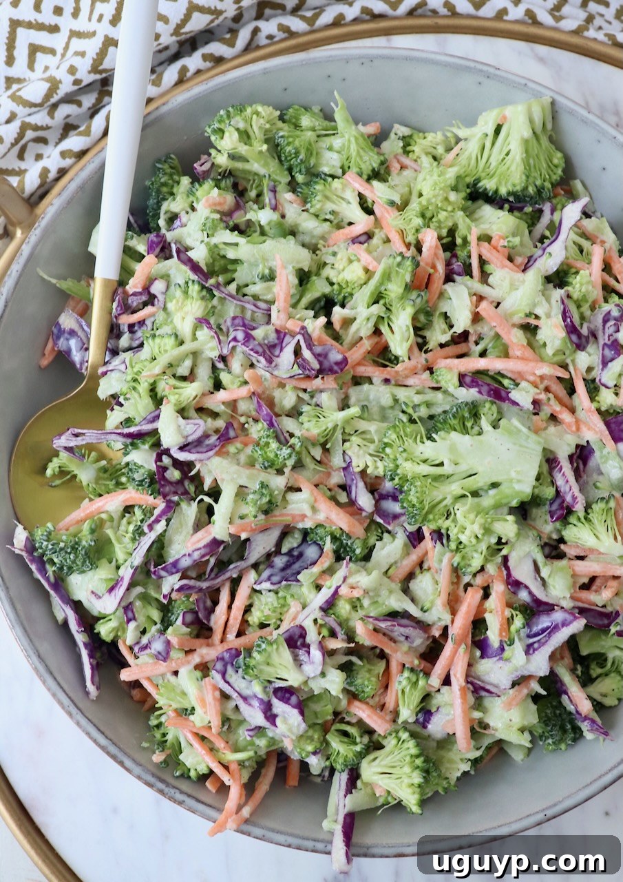 Vibrant broccoli slaw served in a large bowl with a spoon, ready to be enjoyed.