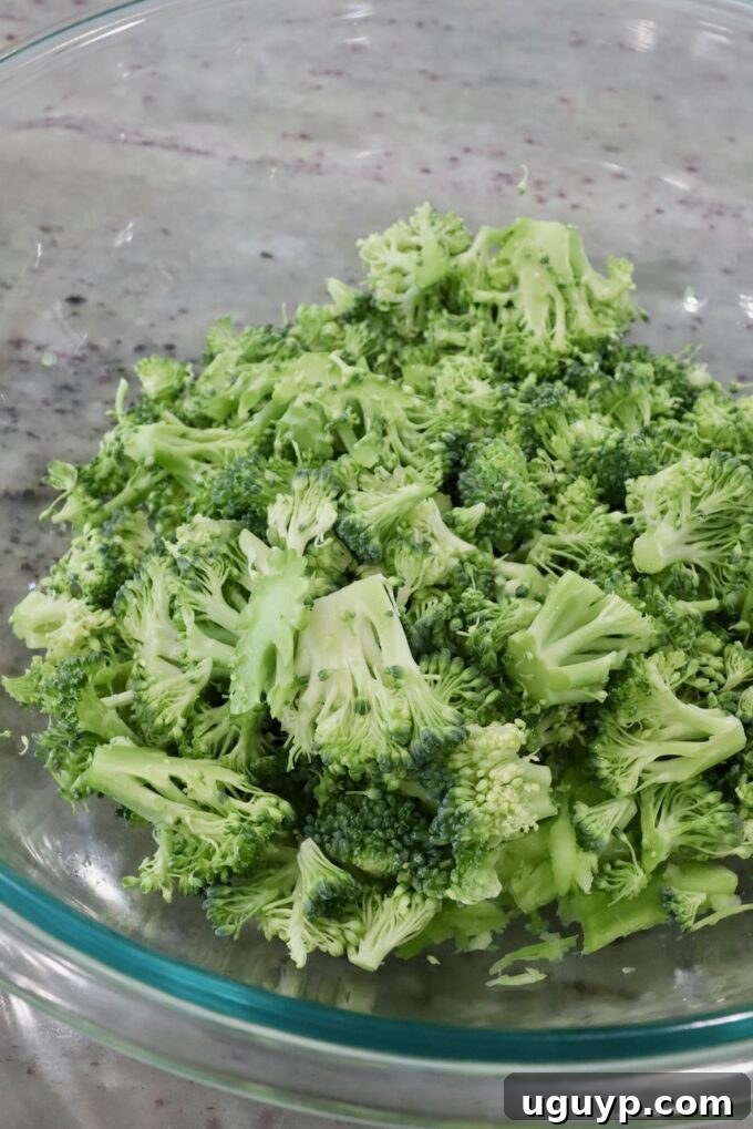 Finely chopped broccoli florets in a bowl, awaiting combination with other slaw ingredients.