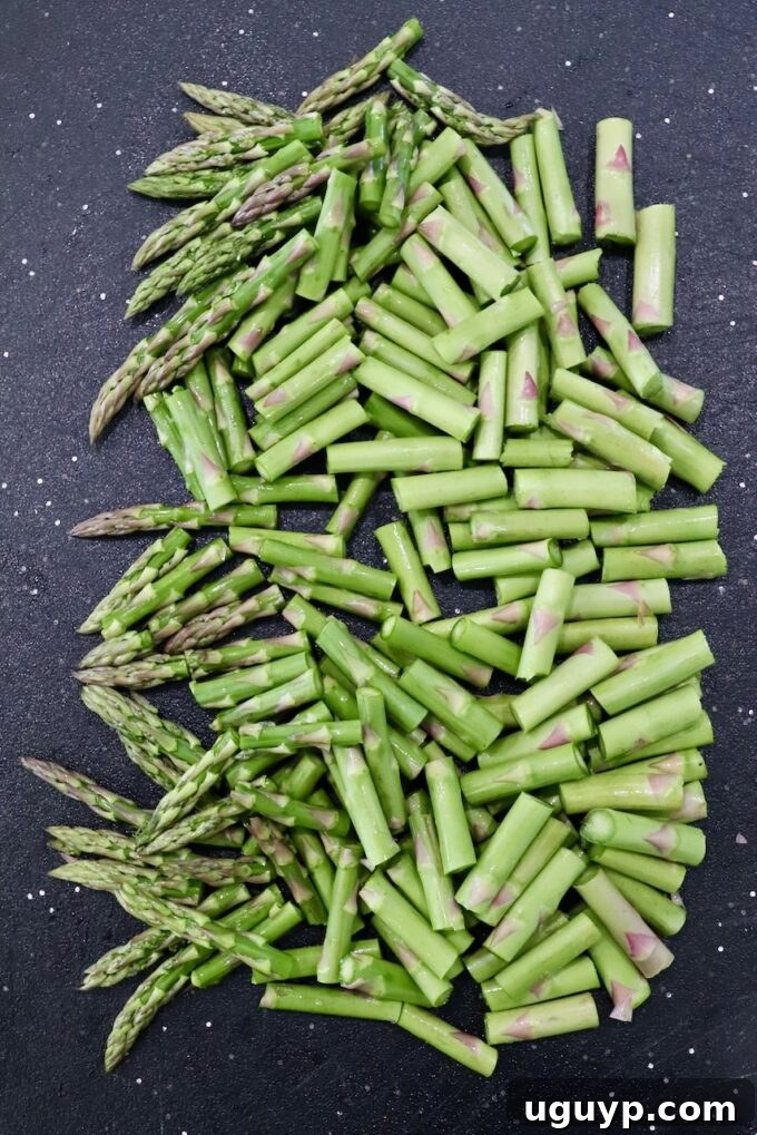 Diced asparagus pieces on a cutting board, ready for stovetop cooking.