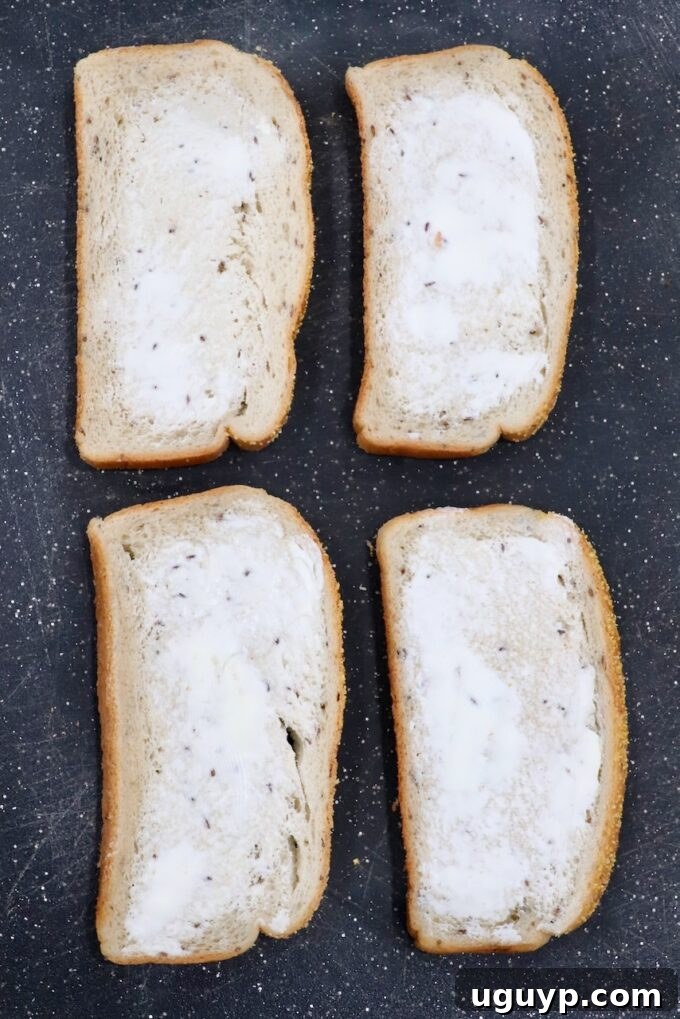 Rye bread slices generously buttered on one side, arranged on a cutting board.