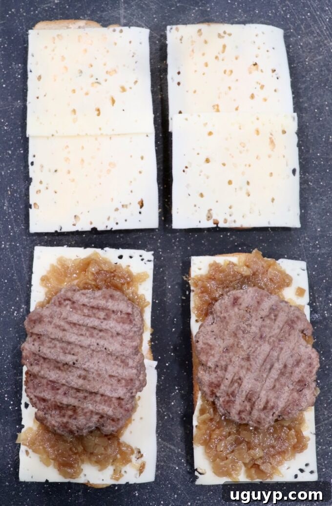 Assembled patty melt components: rye bread, Swiss cheese, caramelized onions, and cooked burger patties.