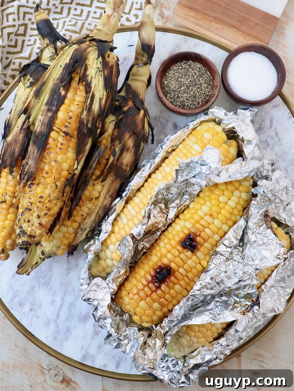 Grilled corn on the cob on a elegant marble platter, showcasing its golden color and slight char.