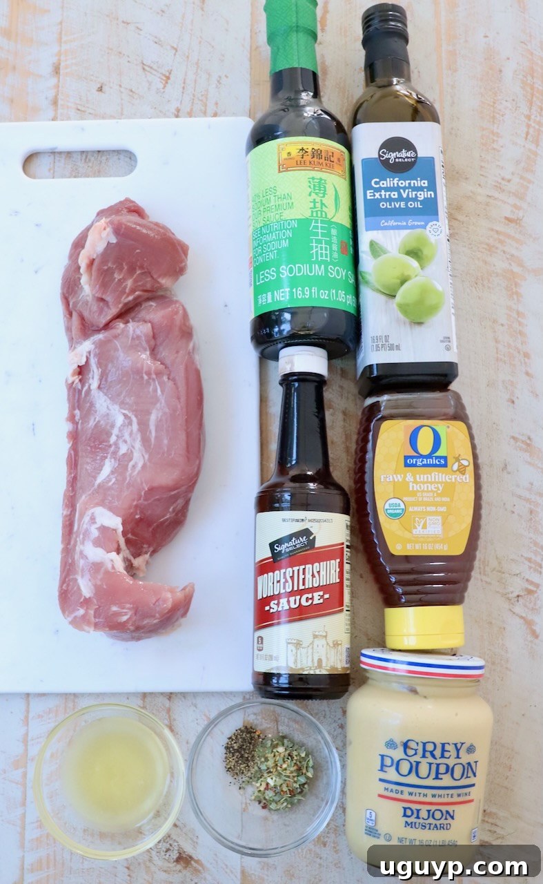 Various ingredients for pork tenderloin marinade laid out on a white wooden board