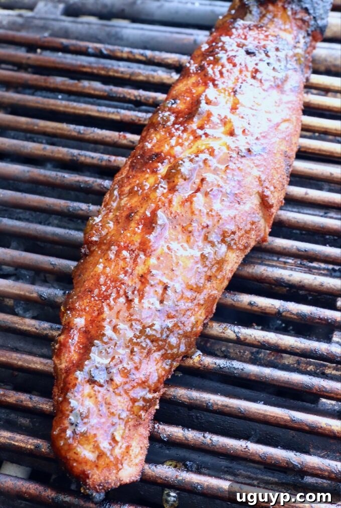 Glazed pork tenderloin on grill.