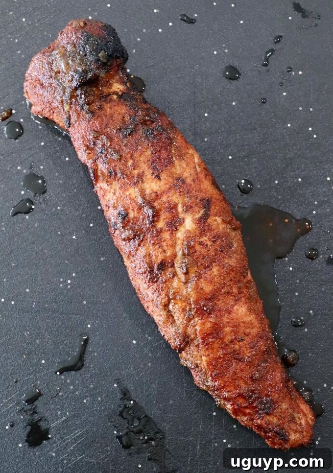 Grilled pork tenderloin on cutting board.