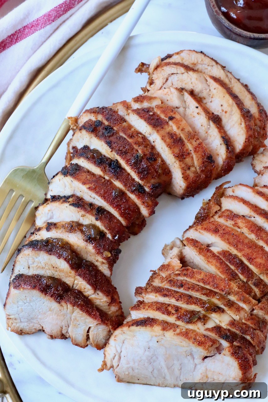 Sliced grilled BBQ pork tenderloin on a plate.