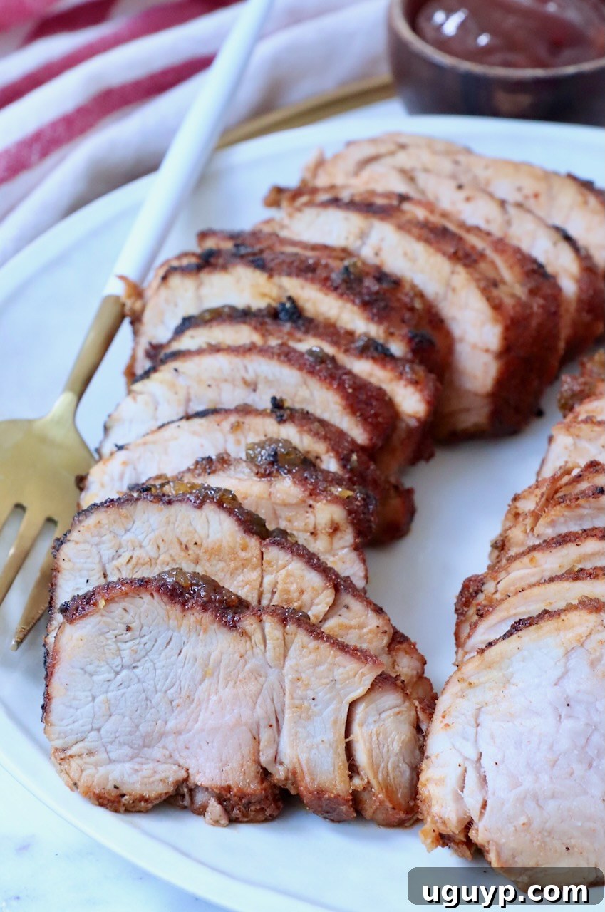Sliced grilled pork tenderloin on plate.