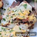 Grilled chicken topped with bacon and cheese sliced in half on plate, a delicious Outback copycat.