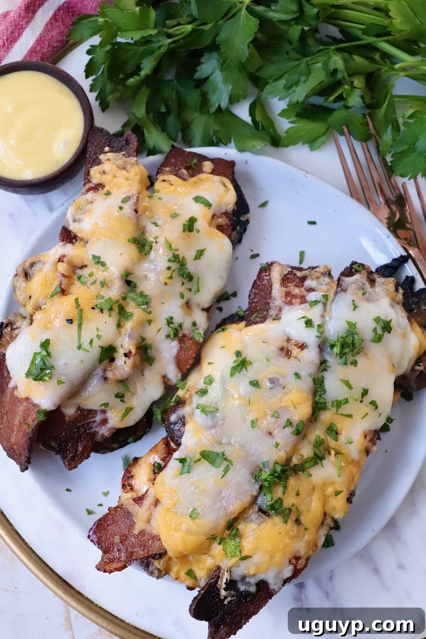 A delicious plate of grilled chicken topped with crispy bacon and melted cheese, sliced in half for a perfect serving presentation.