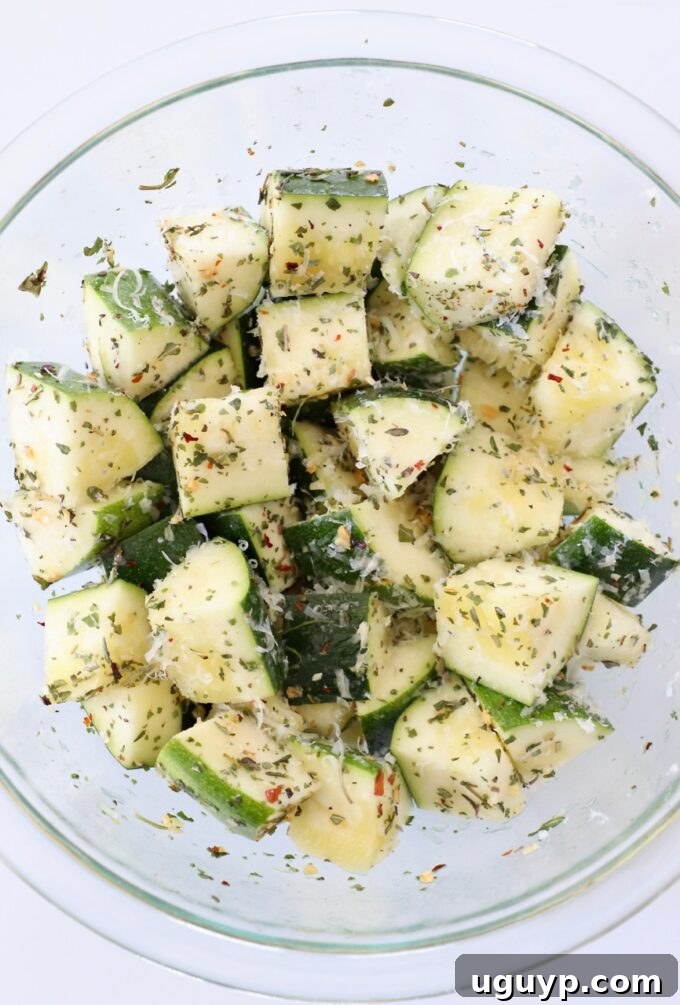 Seasoned diced zucchini in a bowl, ready for the air fryer