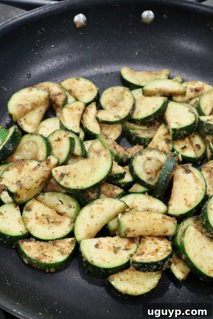 Cooked slices of zucchini in a skillet, lightly browned