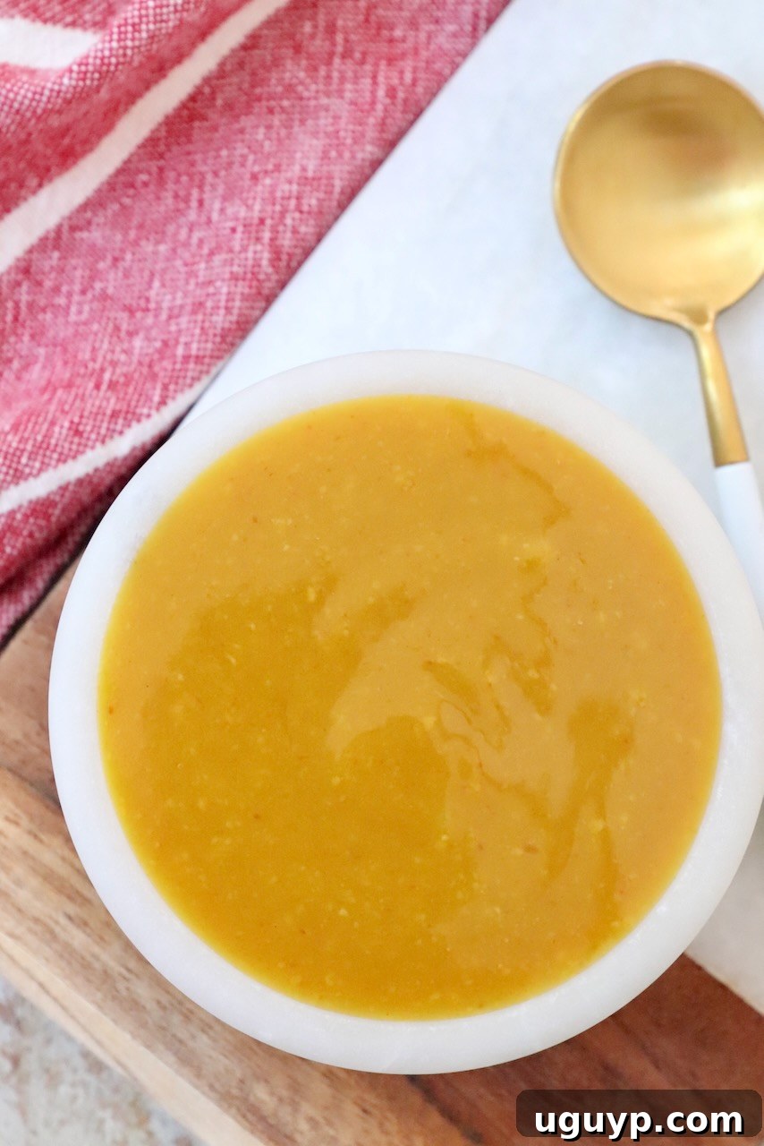 mustard bbq sauce in small bowl with spoon