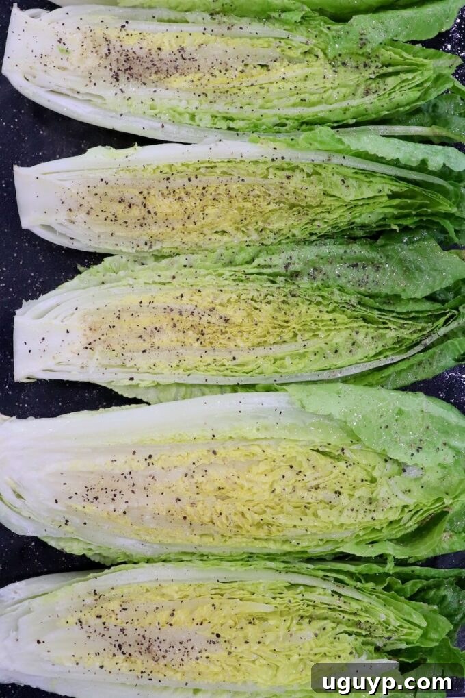 seasoned romaine lettuce hearts cut in half and seasoned on cutting board