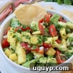 diced mango, avocado and tomatoes in bowl with tortilla chip
