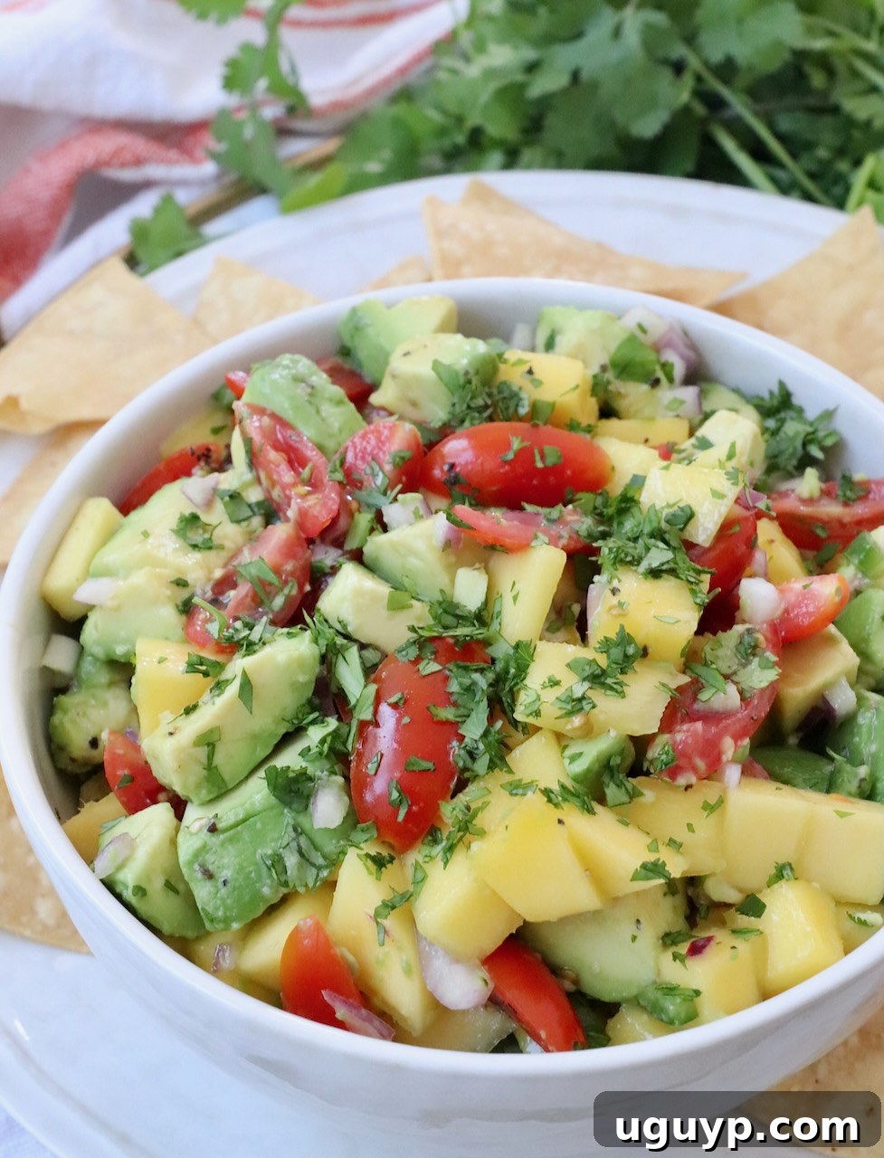 mango avocado salsa in bowl on tray with tortilla chips