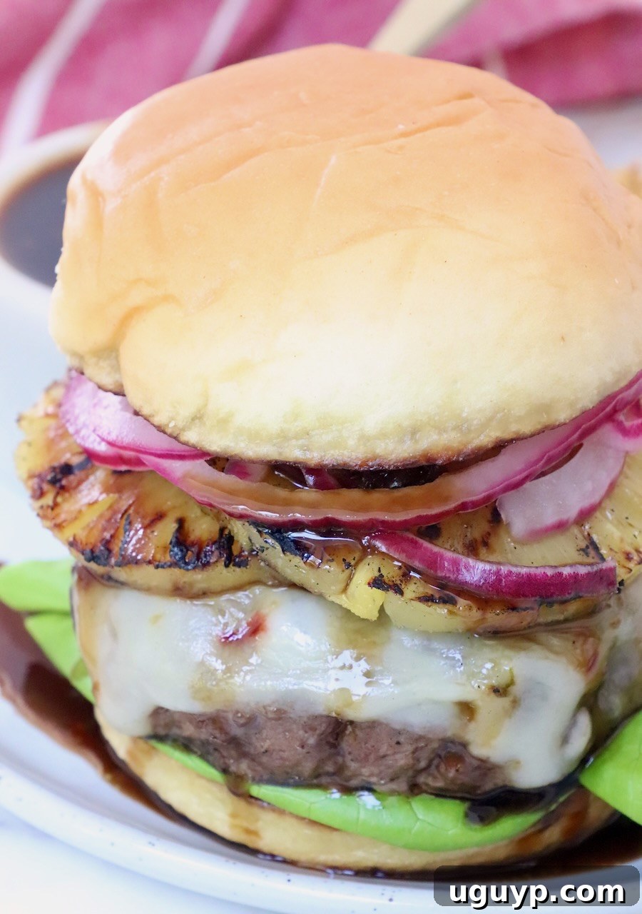 cooked cheeseburger on plate with teriyaki sauce and grilled pineapple