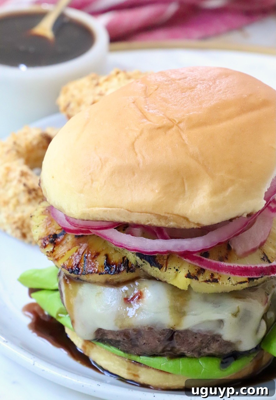 cooked cheeseburger on plate with a small bowl of teriyaki sauce