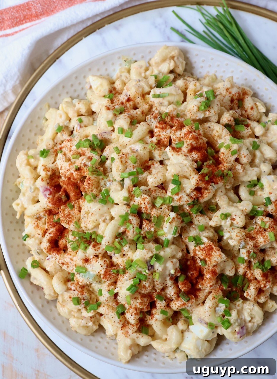 deviled egg pasta salad in bowl topped with paprika and chopped chives