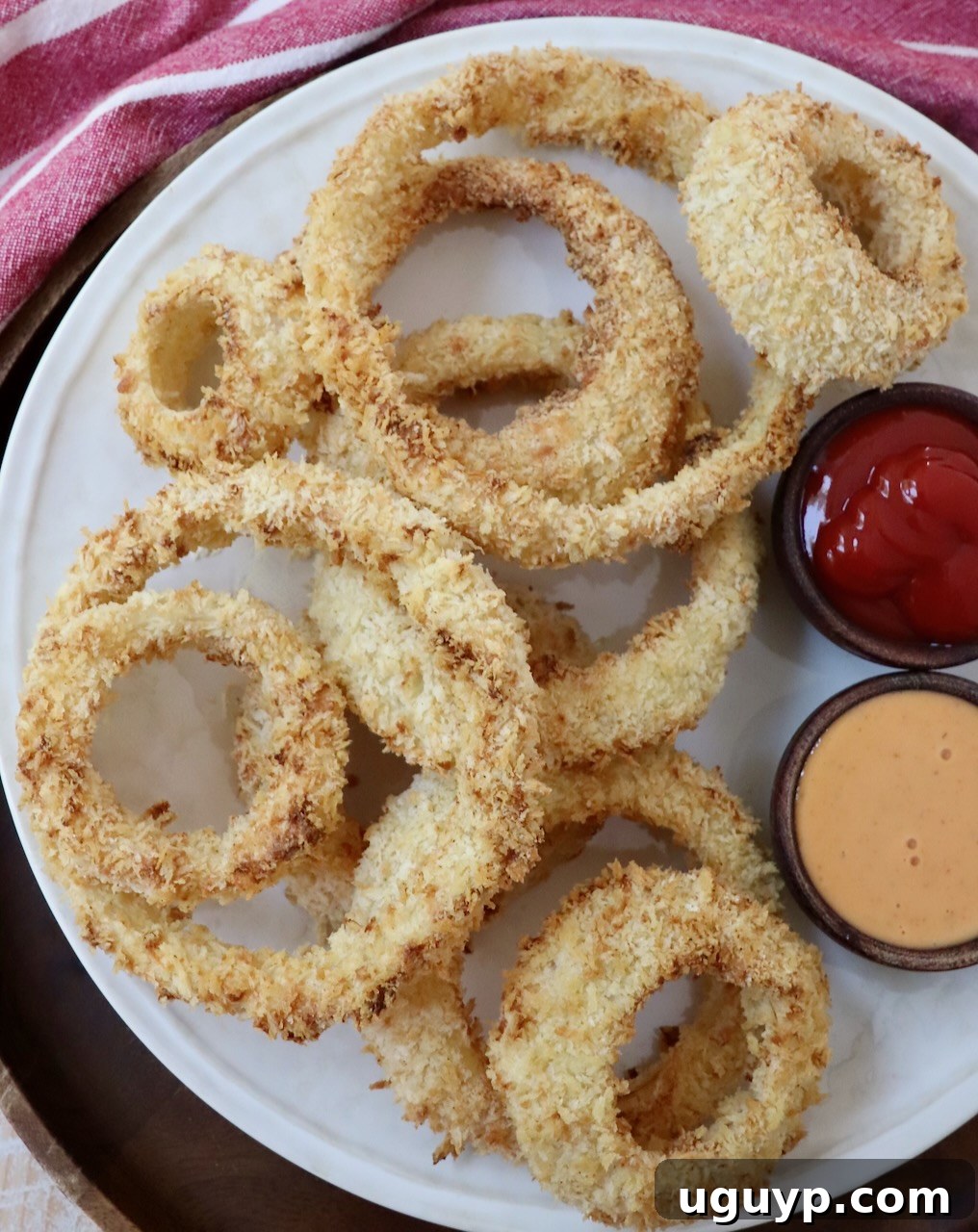 onion rings on plate with dipping sauces in small bowls on the side