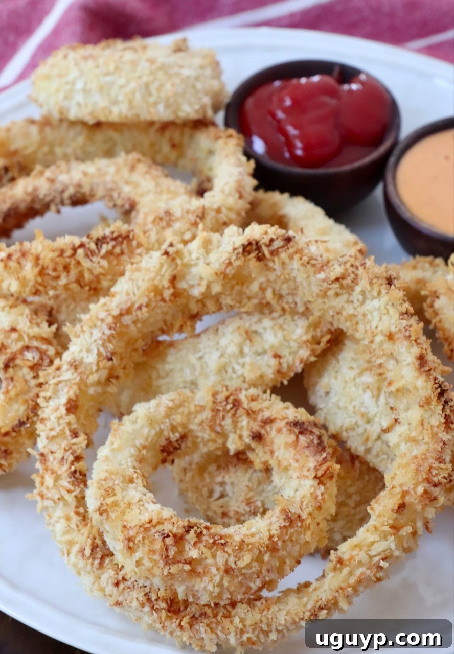 air fried onion rings on plate with small bowls of sauce on the side