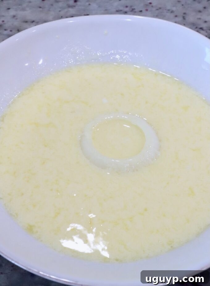 a slice of onion in a bowl of buttermilk