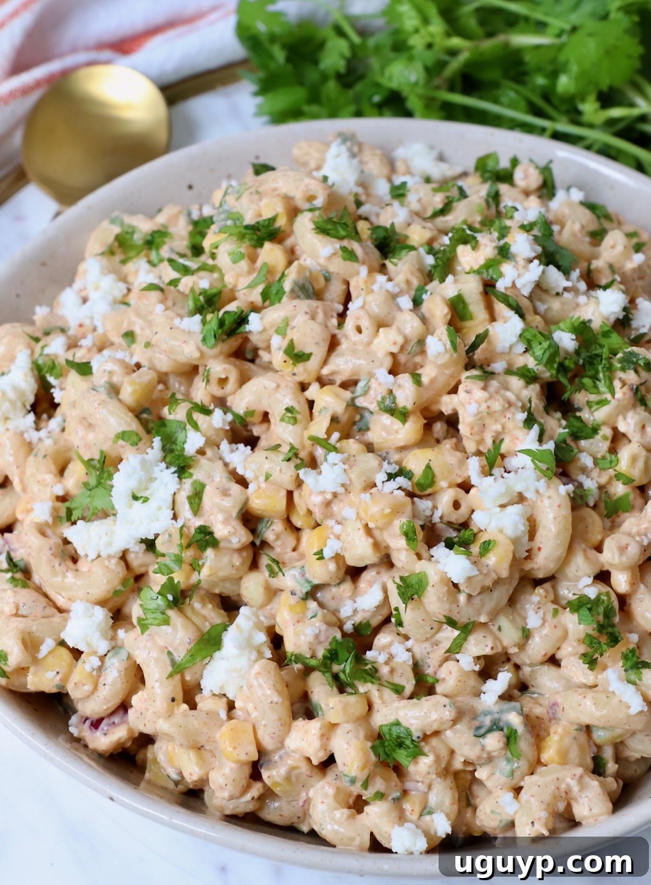 Vibrant Mexican Street Corn Pasta Salad in a serving bowl, garnished with fresh cilantro and cotija cheese.