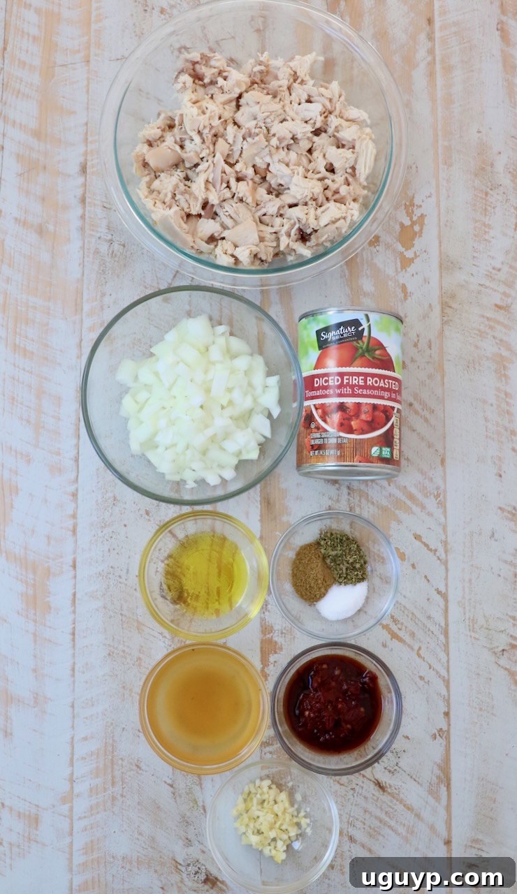 ingredients for chicken tinga on white wood board
