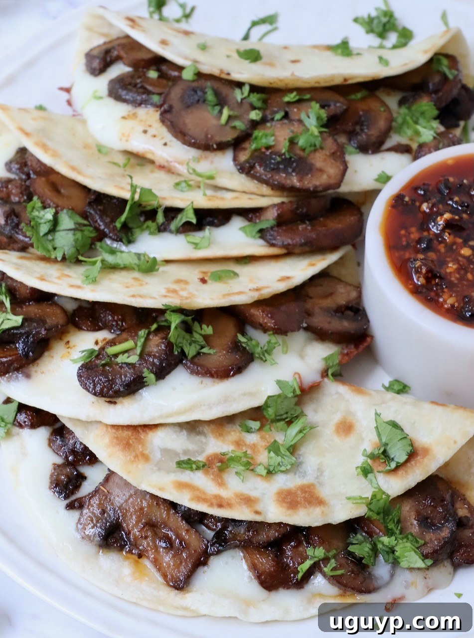 A stack of golden-brown mushroom tacos, garnished simply, emphasizing their inviting texture and appearance.