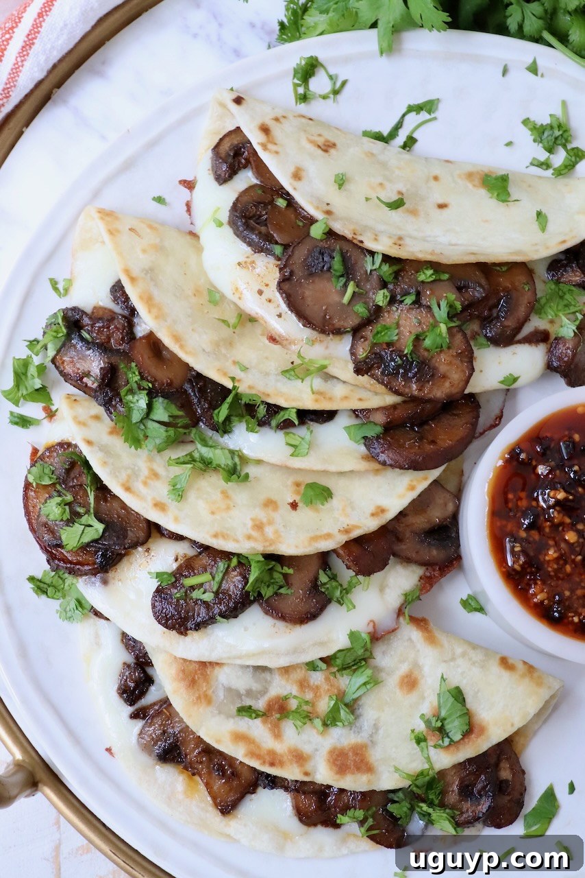 Another enticing view of mushroom tacos stacked on a plate, emphasizing their appetizing presentation and golden tortillas.