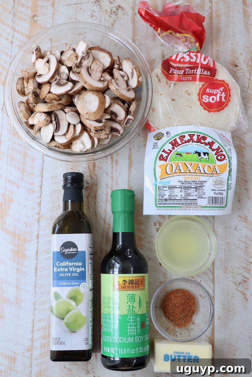 Arrangement of fresh ingredients for mushroom tacos on a rustic white wooden board, highlighting the quality of components.