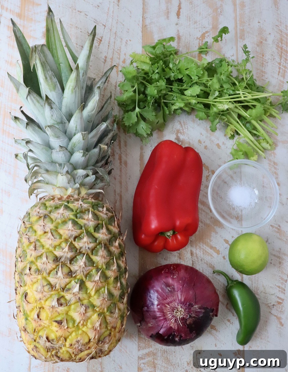ingredients for pineapple salsa laid out on a white wooden board